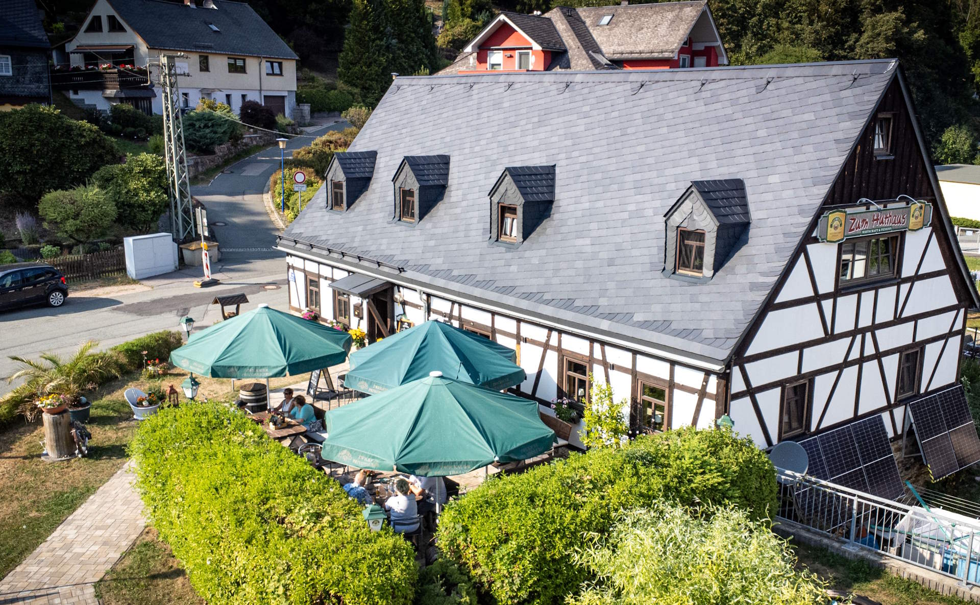 Fachwerkhaus Zum Huthaus in Bad Schlema mit Biergarten und grünen Schirmen